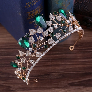 Macro detail of luxury baroque bridal crown with emerald crystals on vintage books