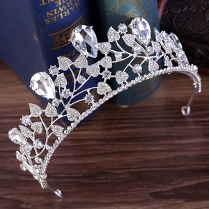 Macro detail of Baroque silver bridal crown with leaf patterns and sparkling teardrop crystals