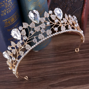 Macro shot of gold-plated baroque bridal crown featuring crystal leaf patterns and rhinestones