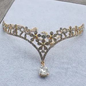 Detail view of crystal floral crown with teardrop pendant on grey velvet background
