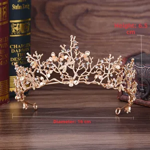 Dettaglio di una corona dorata con strass e rami su uno sfondo in legno vintage