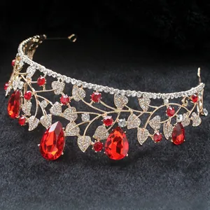 Detail of baroque gold wedding crown with large red teardrop gems and sparkling crystals
