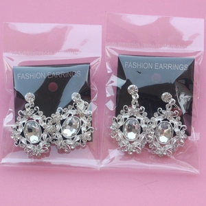 Macro shot of oval bridal earrings with silver plating and clear crystal floral patterns