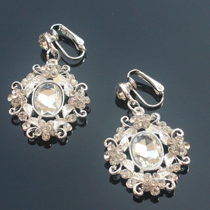Detail of silver drop earrings with oval crystal center and intricate pavé setting