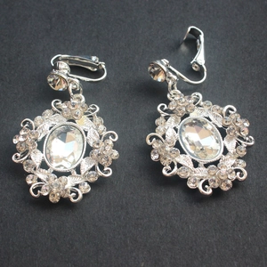 Macro detail of silver bridal earrings featuring oval crystals and retro floral metalwork