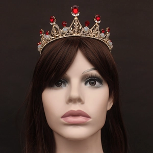 Détail du diadème de mariée doré avec strass rouges et perles blanches de luxe