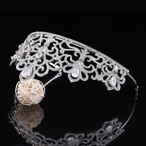Gros plan de la couronne de mariée argentée avec motifs de volutes et strass en forme de larme