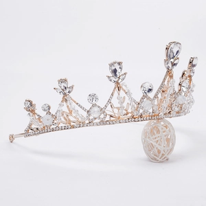 Détail d'une couronne de mariée dorée avec cristaux brillants sur support blanc