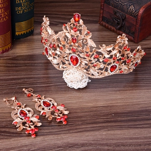 Detail van de barokke gouden kroon en rode edelsteen oorbellen op vintage hout