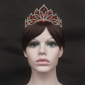 Detailed view of European bridal crown with red rhinestones on gold filigree metal base