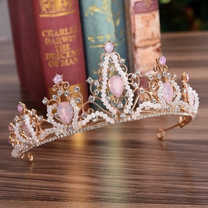 Close-up of golden bridal crown with pink crystals and handcrafted pearl beading