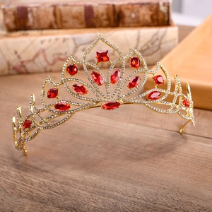 Detailed close-up of golden crown featuring vibrant red square and marquise rhinestones