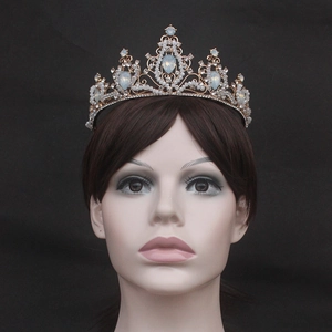 Close-up of golden bridal crown with blue opal drops and crystals on model
