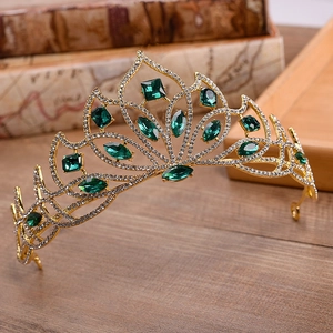 Detailed close-up of emerald green crystals on a gold bridal crown with white rhinestones