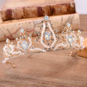 Detailed macro view of bridal tiara featuring opal stones and white beads on vintage books