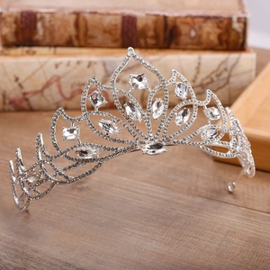 Detailed side view of silver bridal crown with crystal flower petals on vintage books