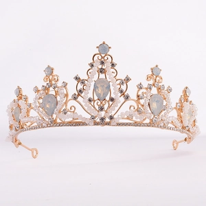 Baroque bridal tiara with golden alloy base, opals, and sparkling crystals on white backdrop