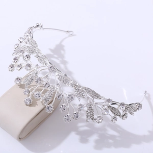 Detailed view of silver bridal tiara with rhinestones on beige display stand