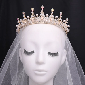 Couronne de mariée dorée élégante avec perles blanches et cristaux sur un modèle