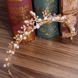 Golden bridal crown with branches, pearls and crystals on a vintage wooden background