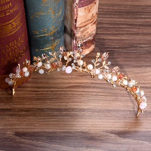 Handmade golden branch tiara with pink beads and crystals on a vintage book background
