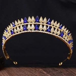 Detail view of gold baroque crown featuring pear-shaped blue crystals and white rhinestones