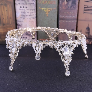 Detailed macro of Baroque bridal crown featuring intricate silver lace and white pearls