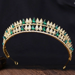 Close-up of golden Baroque bridal crown featuring green teardrop crystals and sparkling rhinestones