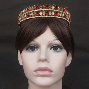 Detailed view of Baroque gold bridal crown with red teardrop crystals on model