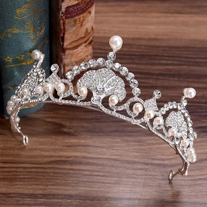 Elegant silver bridal crown with pearls and rhinestones on a vintage wooden surface