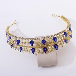 Detailed macro view of baroque golden crown with blue teardrop crystals and rhinestones
