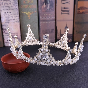 Baroque hollow gold bridal crown with white pearls and rhinestones on a vintage background