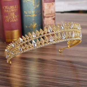 Close-up of golden bridal tiara with teardrop crystals on a vintage wooden desk