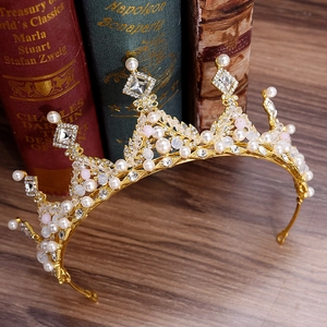 European bridal crown with pearls and crystals displayed on vintage wood background