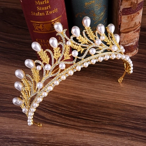 Detailed macro shot of vintage gold bridal crown with white pearls and sparkling rhinestones