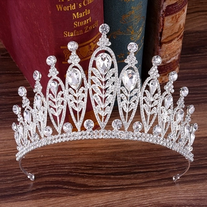 Detailed close-up of a silver baroque tiara featuring crystal leaves on vintage books