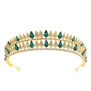 Macro detail of golden bridal tiara with green teardrop gemstones and white crystals