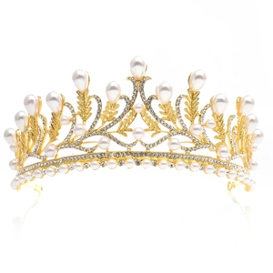 Elegant gold bridal crown featuring crystal leaves and teardrop pearls on a mirror surface