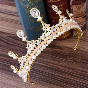 Couronne de princesse dorée avec perles et cristaux sur des livres anciens