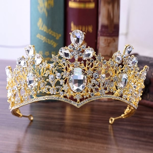 Ornate Baroque gold bridal crown with sparkling white crystals on vintage wooden background