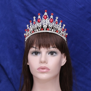 Macro detail of bridal crown featuring silver leaves, red teardrop stones and rhinestones