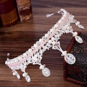 Couronne de princesse avec perles roses et blanches sur un coffre de style vintage