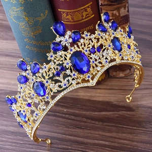 Detail of vintage gold crown with navy blue crystals and rhinestones by old books