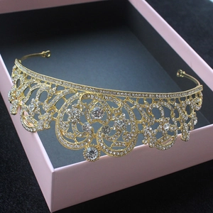 Detailed close-up of a golden bridal crown with sparkling rhinestones on a display box