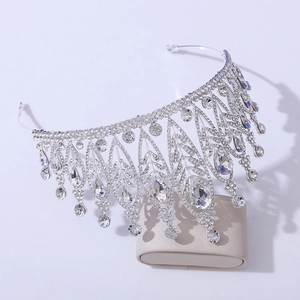Detailed side view of silver leaf crown with rhinestones on a display stand