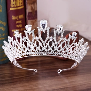 Elegant silver bridal crown with teardrop rhinestones on a rustic wooden background