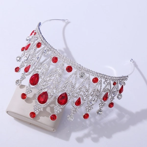 Close-up of baroque silver bridal crown with red gemstones and intricate crystal leaf details