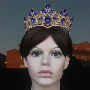Detailed shot of golden baroque crown featuring vintage dark blue crystals and intricate filigree