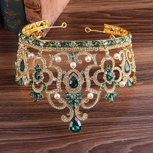 Détail d'une couronne baroque dorée avec pierres vertes et incrustation de perles