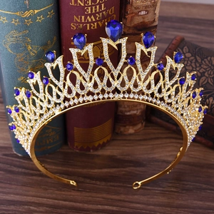 Golden bridal crown with blue teardrop gemstones and white rhinestones on vintage books